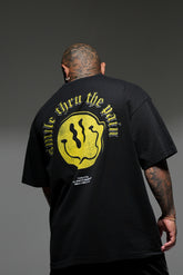 Person wearing a black t-shirt with yellow graphic and text on the back against a gray background